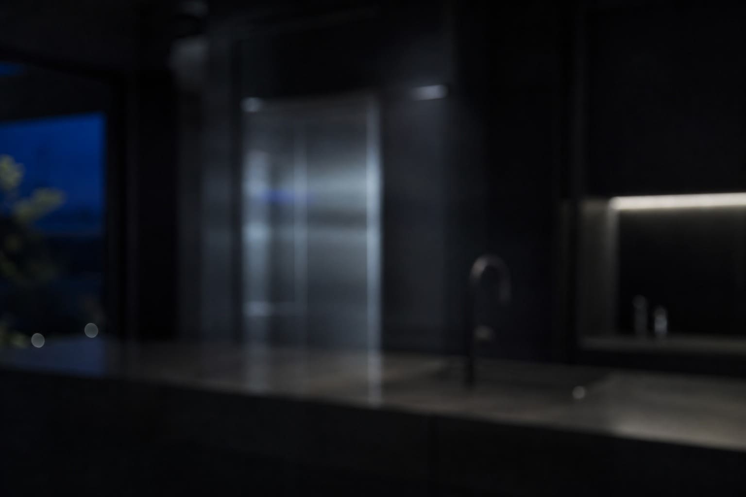 Dark minimal Cupertino kitchen at night with cool stainless highlights